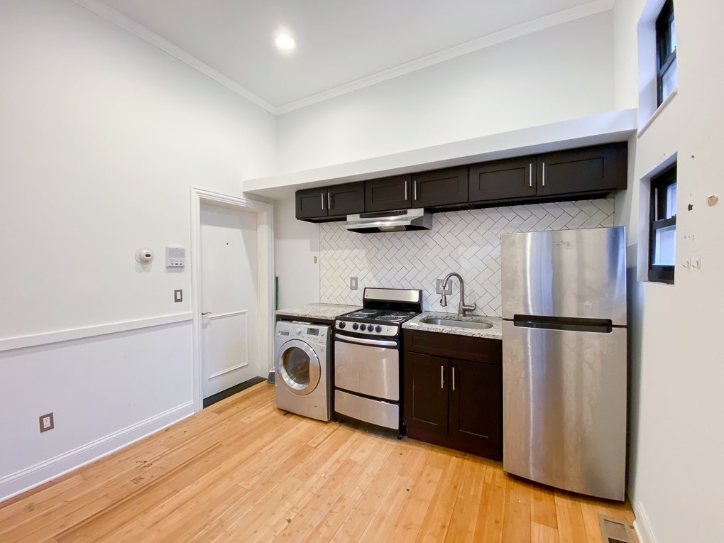 A kitchen with wooden floors and stainless steel appliances.